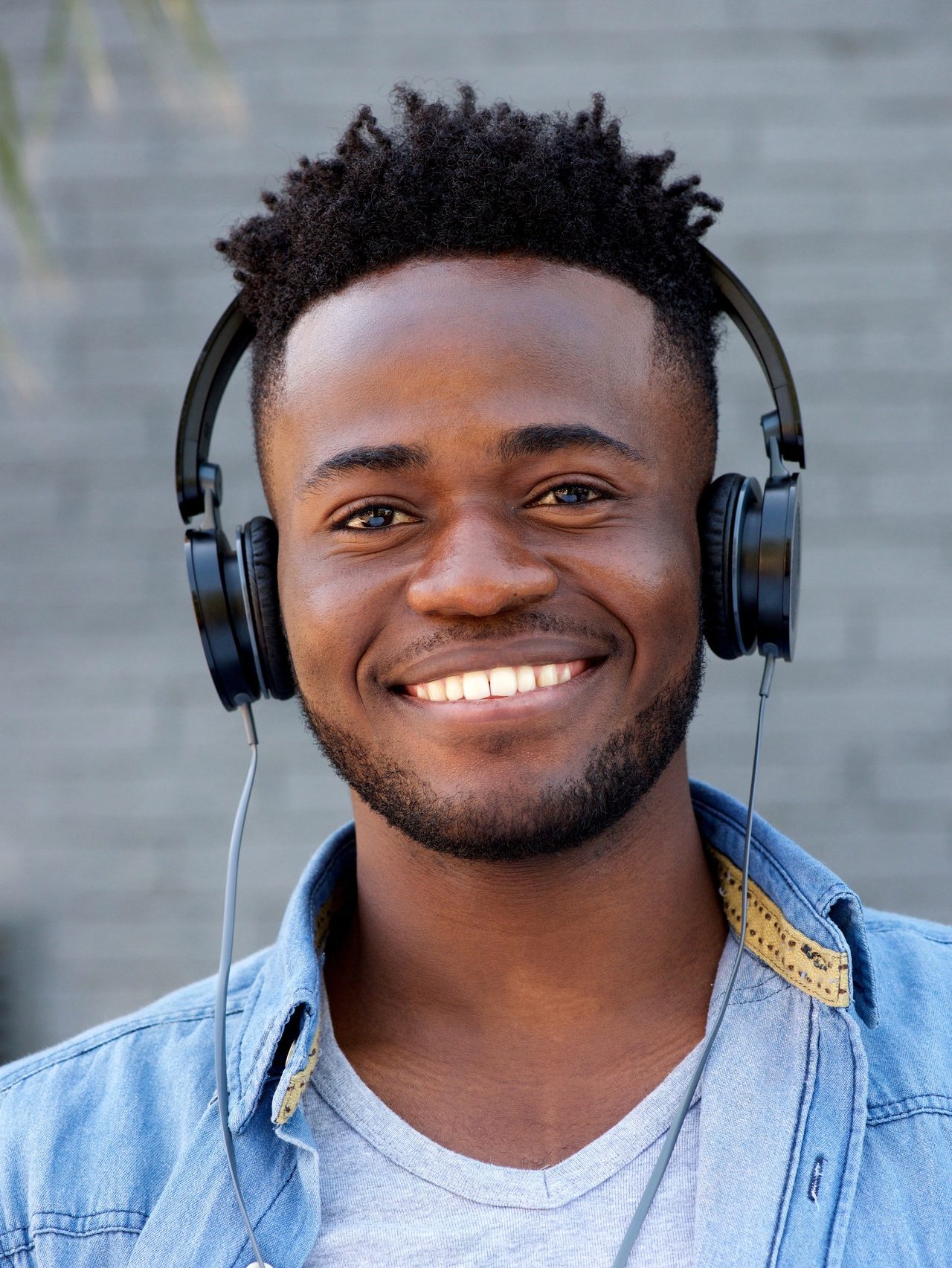 Close up cool young black guy listening to music with headphones